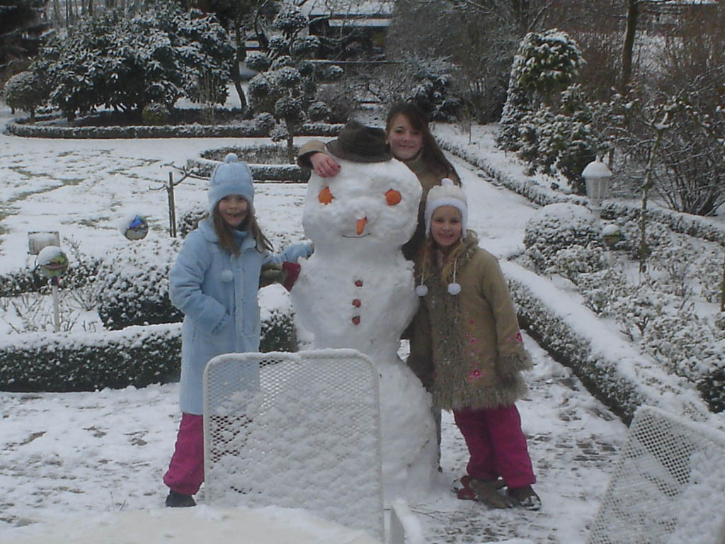 Kinder im Schnee beim Schneemann bauen